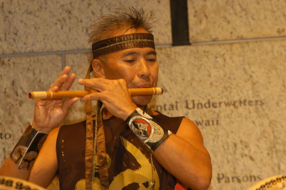 Kenny Endo playing a flute-like wooded instrument